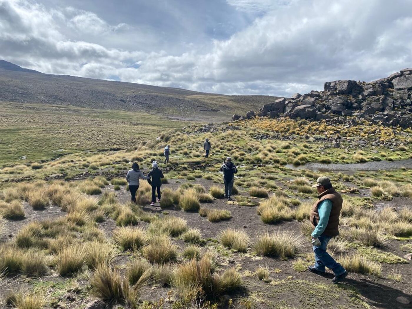 Team walking to the spring, showing human scale in the Andean landscape
